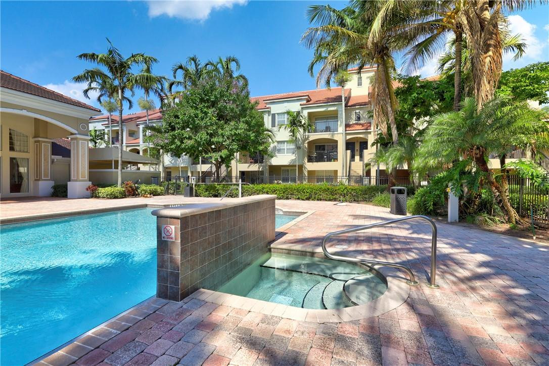 5840 West Sample Road, Unit 308 Coral Springs, FL 33067 - Photo 36 of 54 a view of a swimming pool with a patio
