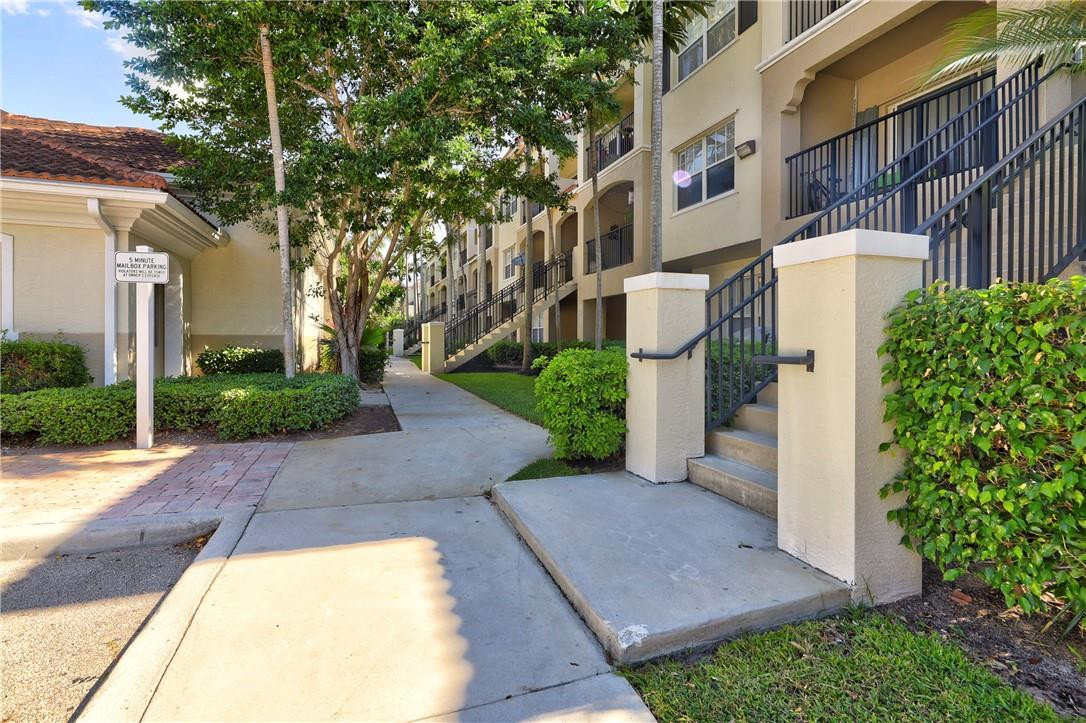 5840 West Sample Road, Unit 308 Coral Springs, FL 33067 - Photo 4 of 54 a view of a white house with a small yard plants and large tree