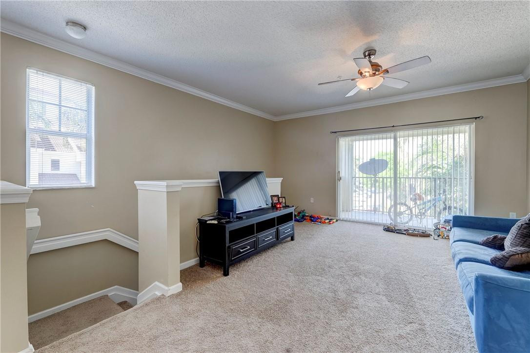 5840 West Sample Road, Unit 308 Coral Springs, FL 33067 - Photo 8 of 54 a living room with furniture and a flat screen tv