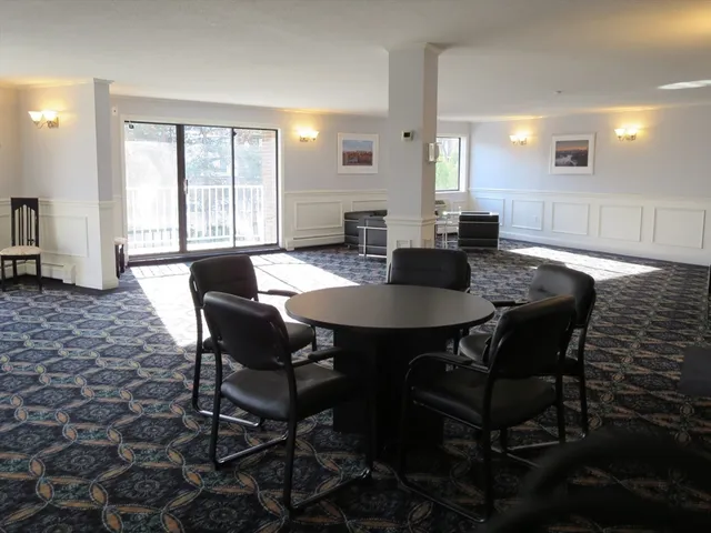 a view of a a dining room with furniture window and wooden floor