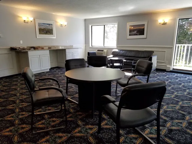 a kitchen with a dining table chairs cabinets and stainless steel appliances