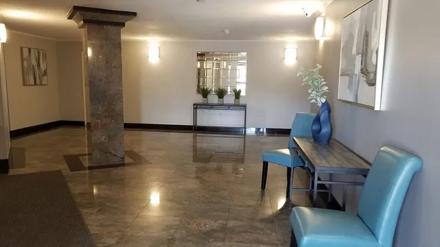 a view of a hallway with furniture and wooden floor