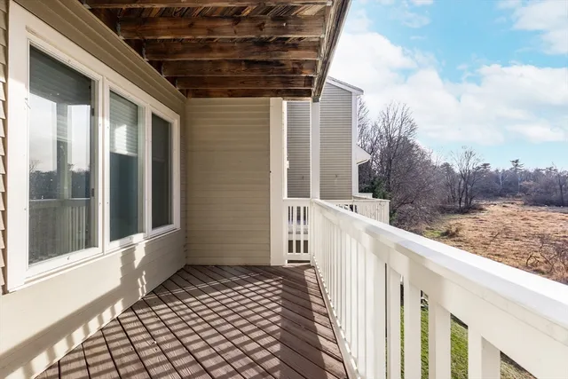a view of a balcony with wooden floor and fence