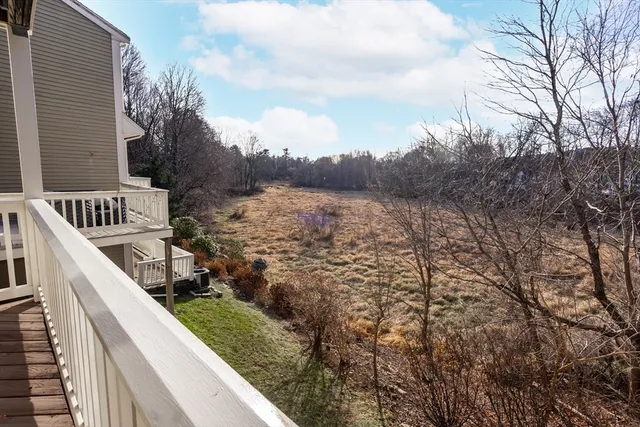 a view of balcony with wooden floor and fence