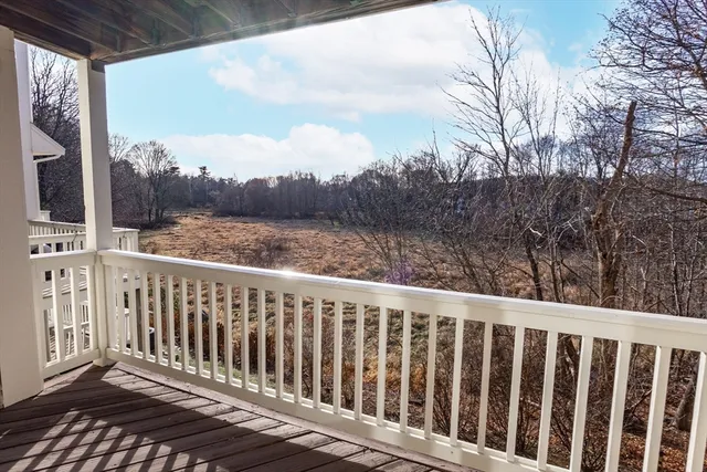 a balcony with wooden floor and yard in back