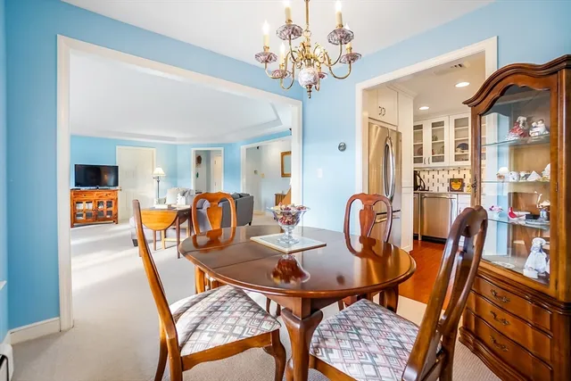 a view of a dining room with furniture a chandelier and wooden floor