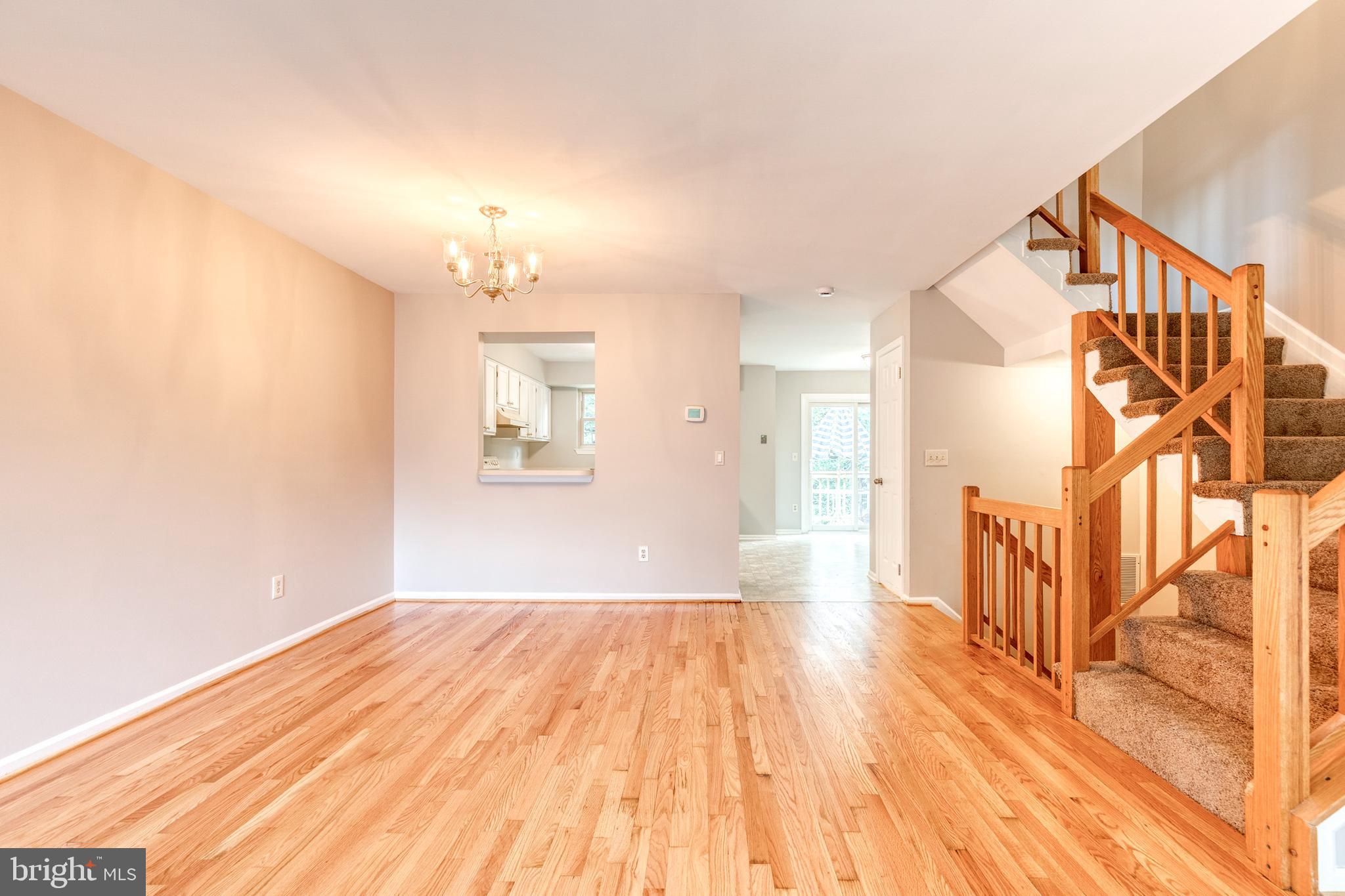 7327 Eden Brook Drive, Unit E30 Columbia, MD 21046 - Photo 5 of 40 a view of an empty room with wooden floor and a window