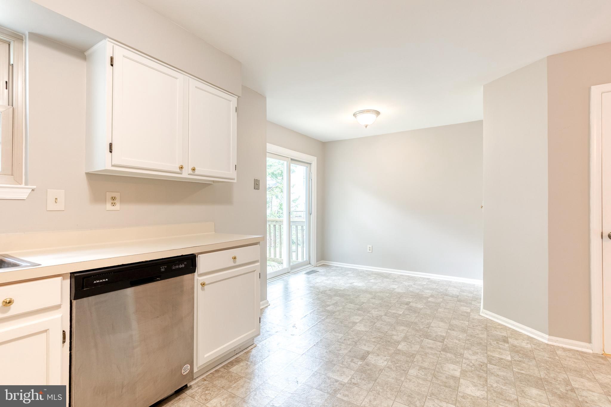 7327 Eden Brook Drive, Unit E30 Columbia, MD 21046 - Photo 9 of 40 a kitchen with granite countertop white cabinets and white appliances
