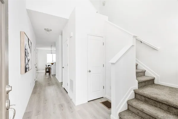 a view of entryway and hall with wooden floor