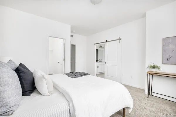 a bedroom with a bed and a refrigerator