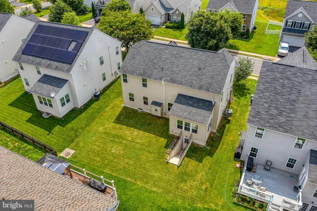 an aerial view of multiple houses with a yard