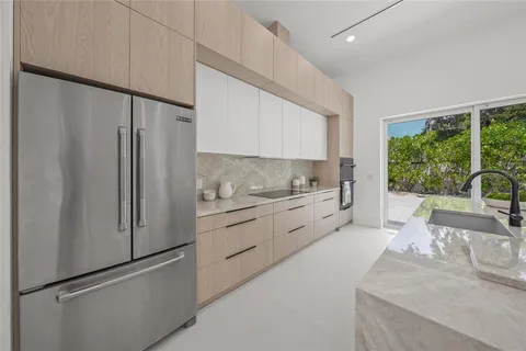 a kitchen with stainless steel appliances granite countertop a sink and a refrigerator