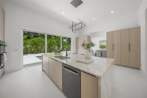 a room with a large window and a potted plant