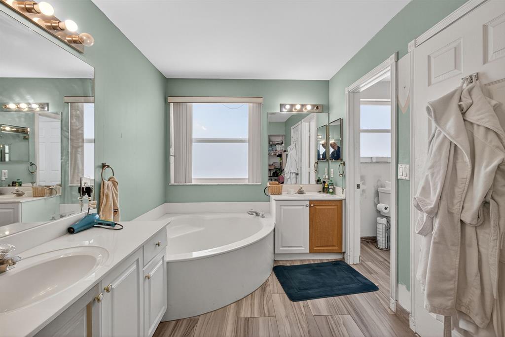 2119 Chagall Circle West Palm Beach, FL 33409 - Photo 44 of 63 a bathroom with a tub sink shower and mirror