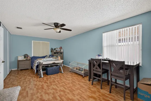 a backyard of a house with table and chairs under an umbrella