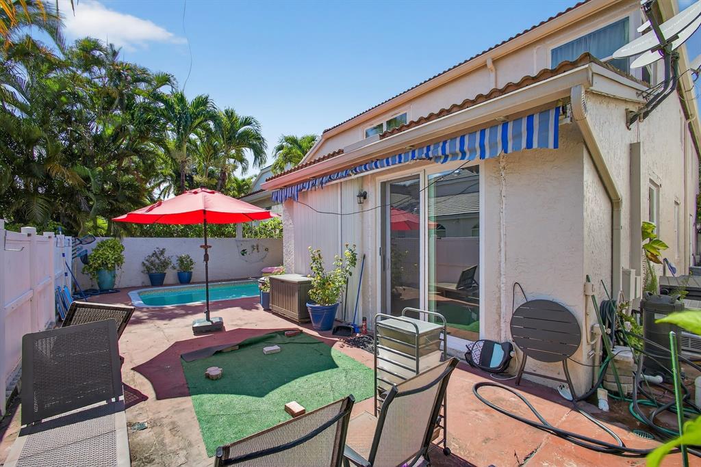 2119 Chagall Circle West Palm Beach, FL 33409 - Photo 58 of 63 a backyard of a house with table and chairs under an umbrella