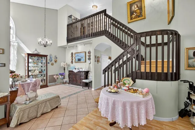 a view of a dining room and livingroom with furniture wooden floor a chandelier