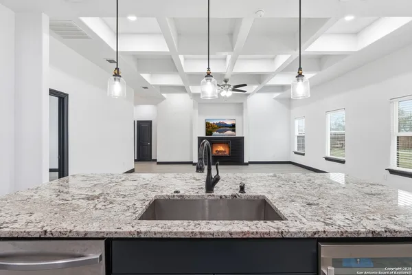 a view of a kitchen with kitchen island a sink and a counter top space