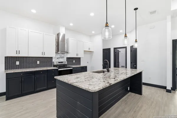 a kitchen with kitchen island granite countertop wooden cabinets and a sink