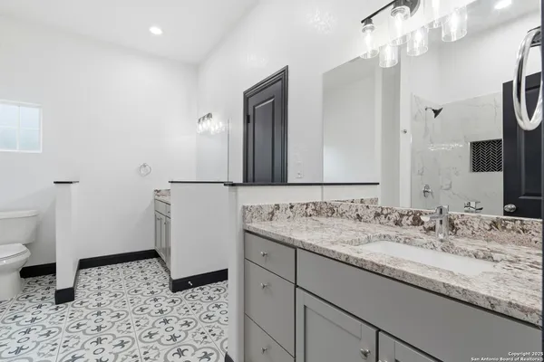 a bathroom with a sink a toilet and a mirror