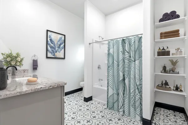 a bathroom with a sink a toilet and shower curtain
