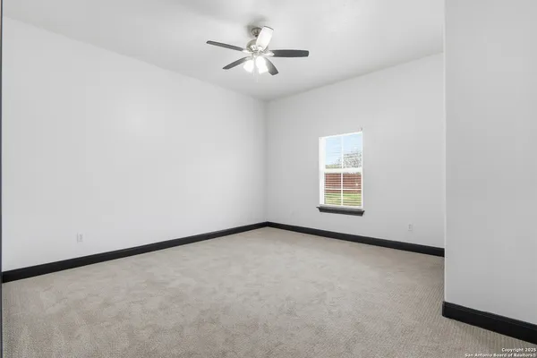 an empty room with a window and a ceiling fan