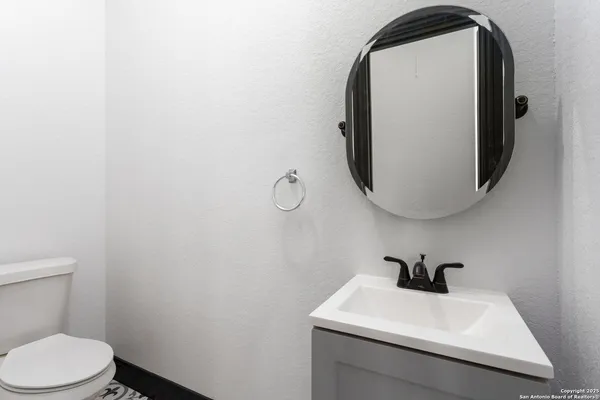a bathroom with a sink and mirror with toilet
