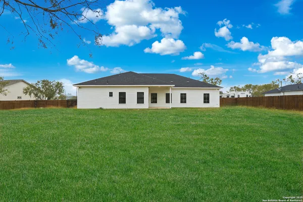 a view of a big yard with a house in the background