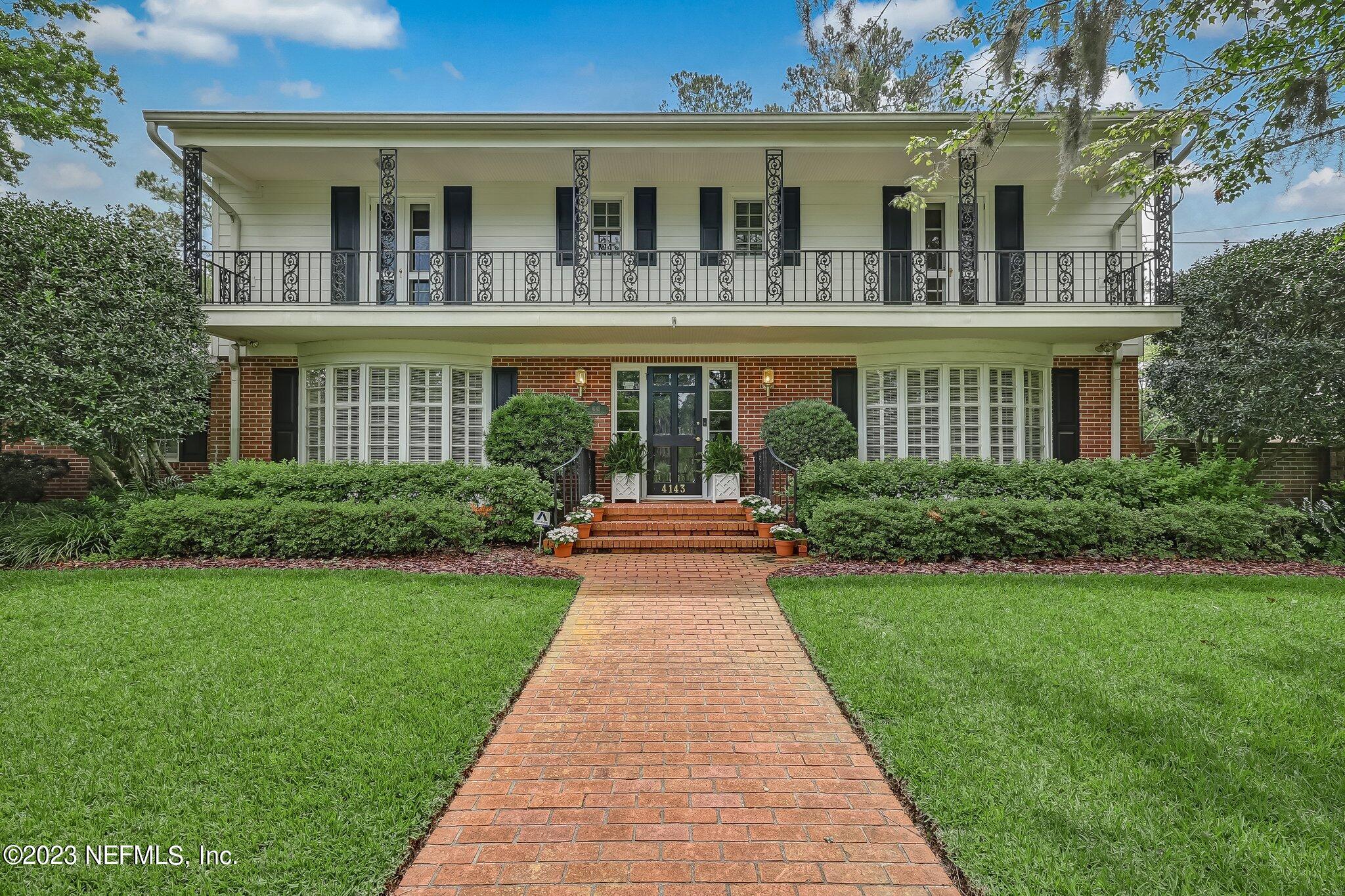 a front view of a house with yard and green space