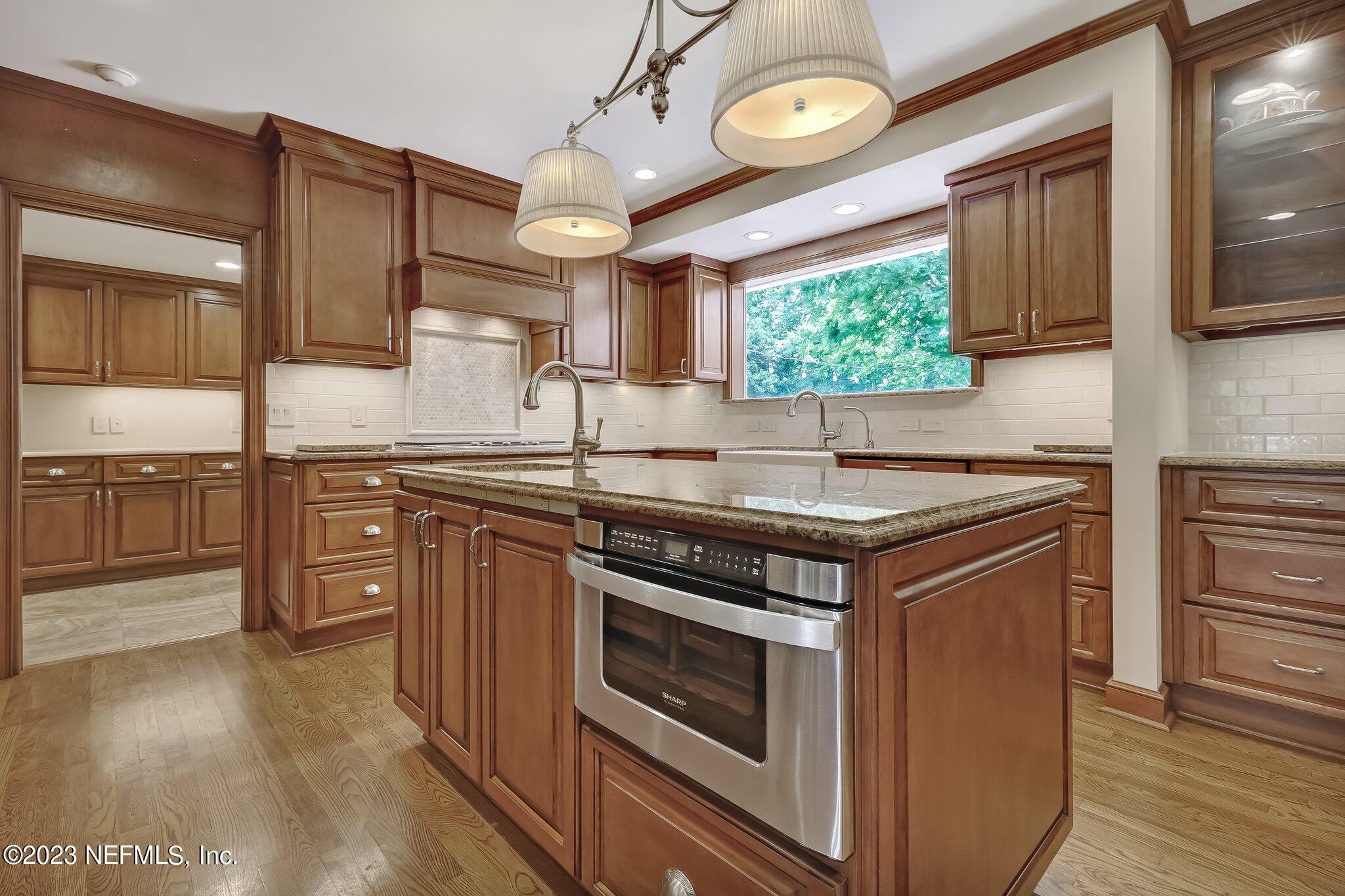 4143 Sherwood Road Jacksonville, FL 32210 - Photo 20 of 67 a kitchen with stainless steel appliances granite countertop a stove a sink and a microwave