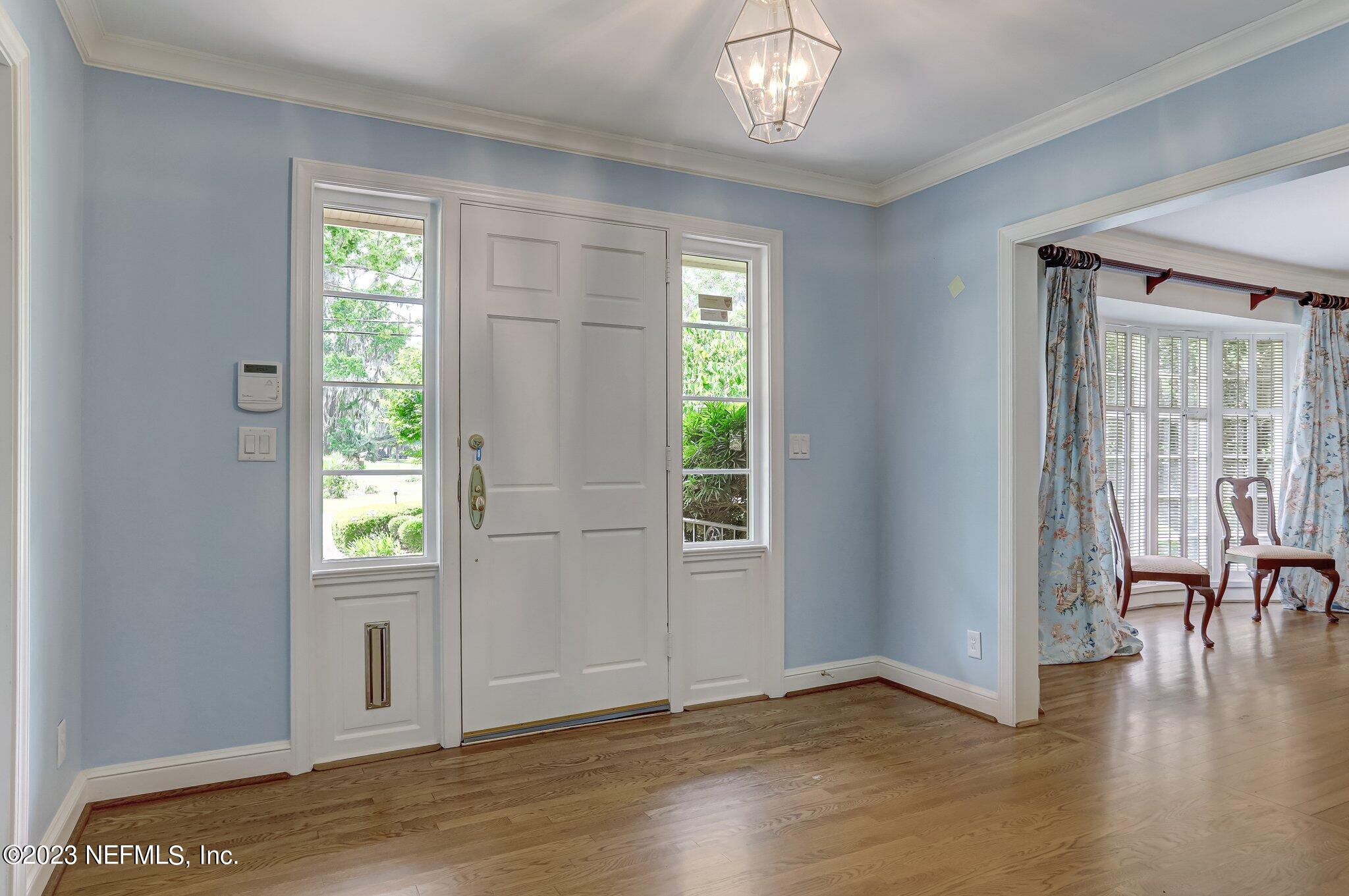 4143 Sherwood Road Jacksonville, FL 32210 - Photo 4 of 67 an empty room with wooden floor fan and windows