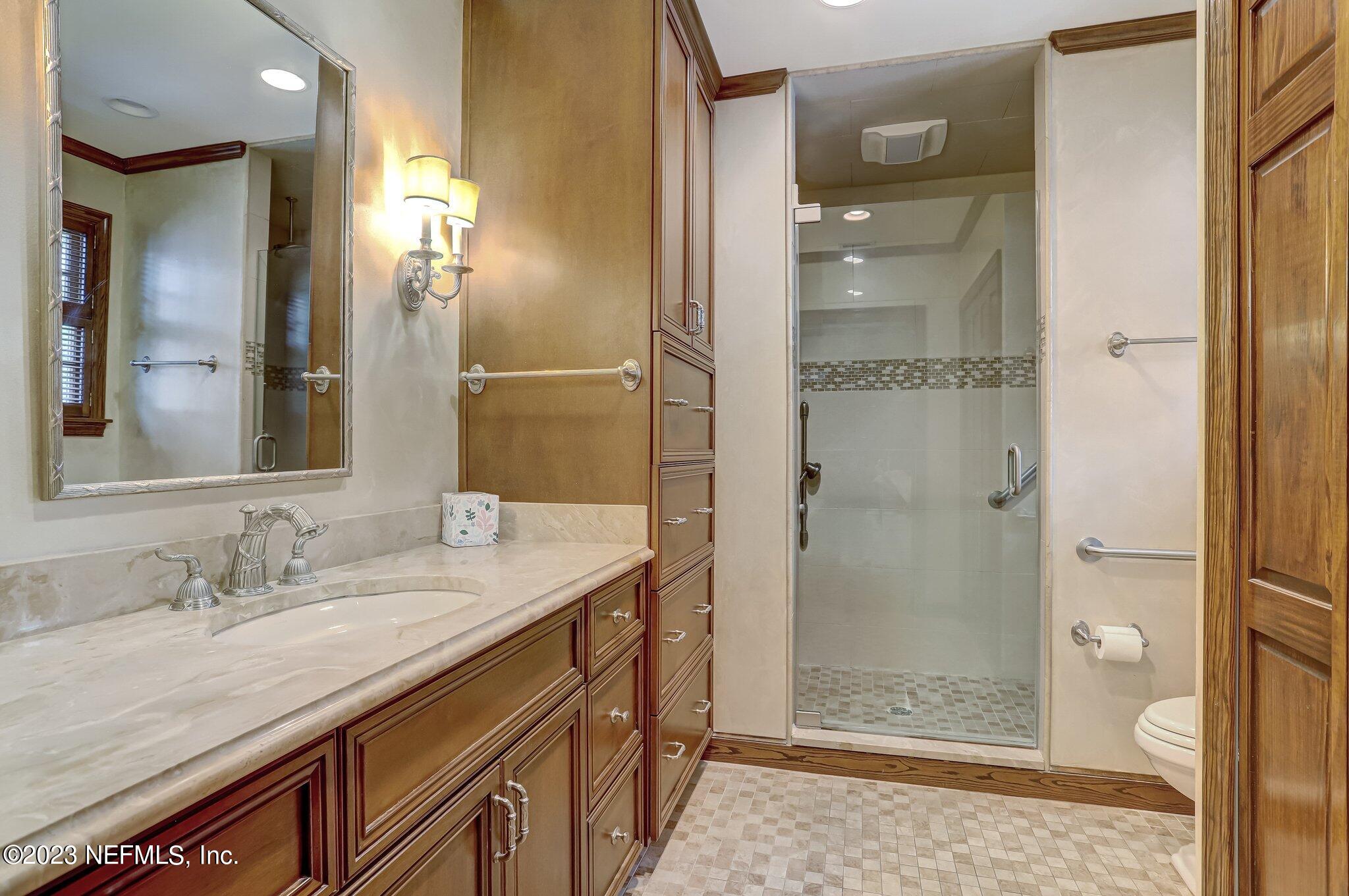 4143 Sherwood Road Jacksonville, FL 32210 - Photo 41 of 67 a bathroom with a granite countertop sink mirror and shower