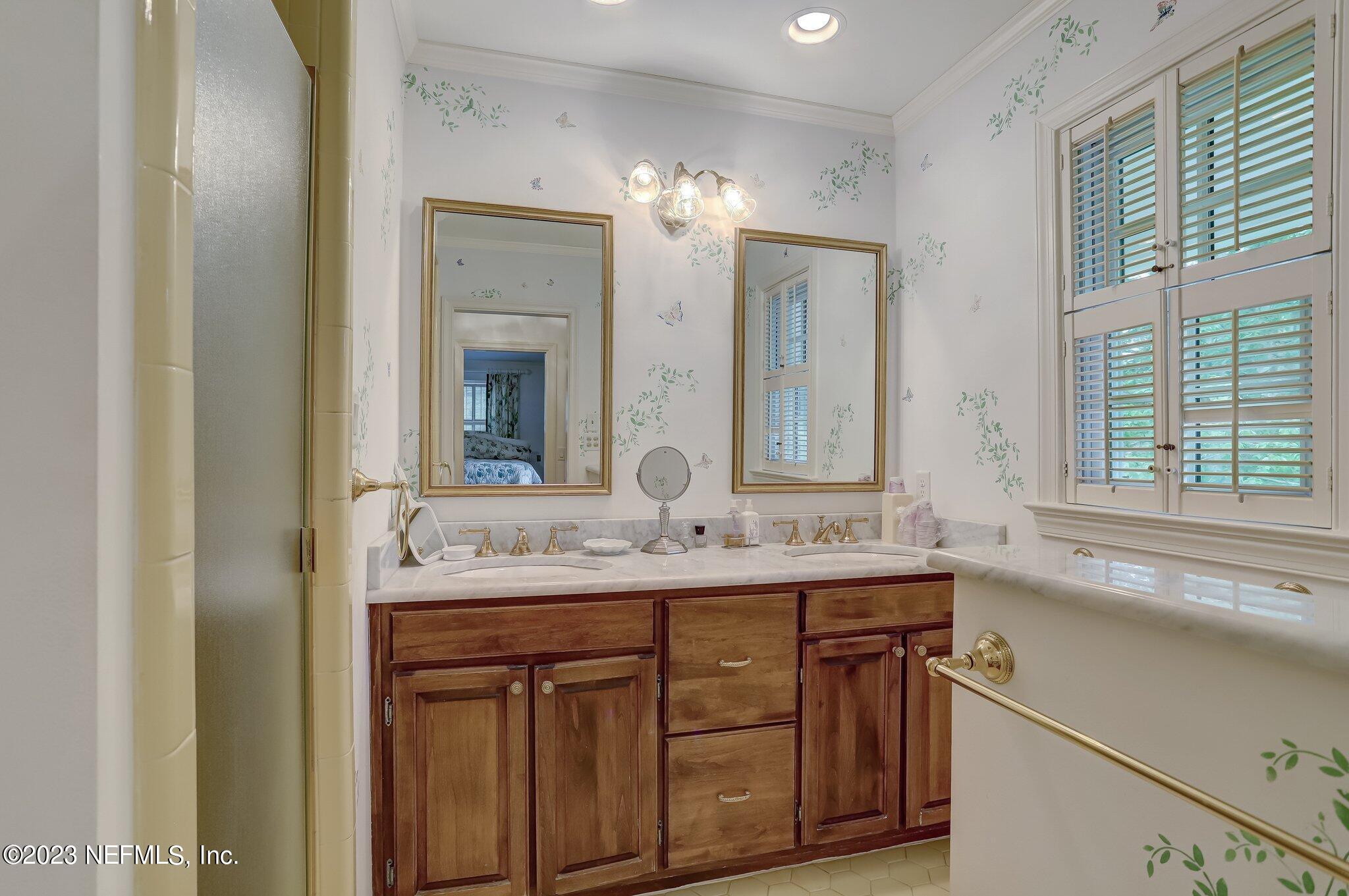 4143 Sherwood Road Jacksonville, FL 32210 - Photo 46 of 67 a bathroom with a double vanity sink and a mirror