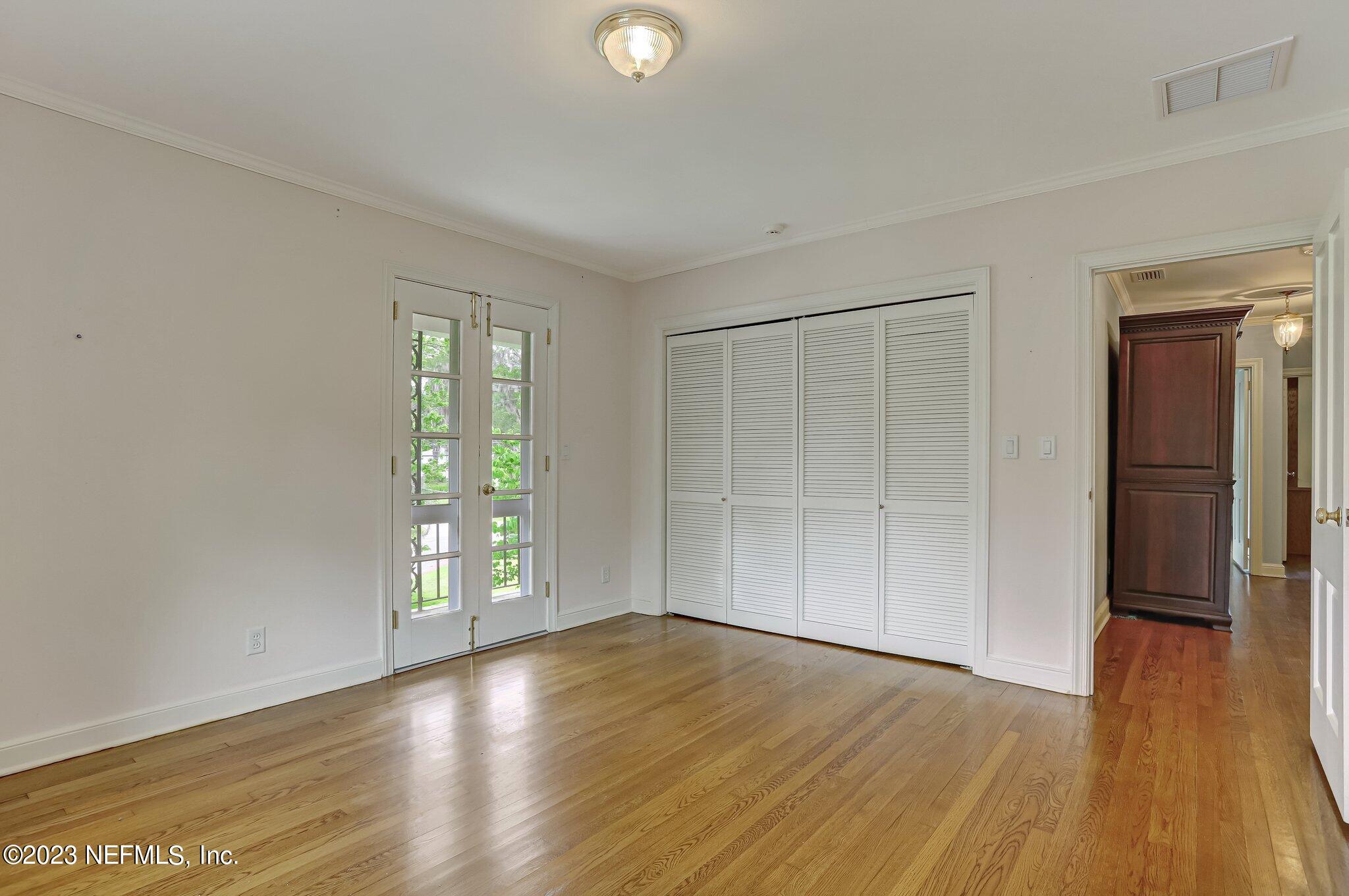 4143 Sherwood Road Jacksonville, FL 32210 - Photo 53 of 67 an empty room with wooden floor and windows
