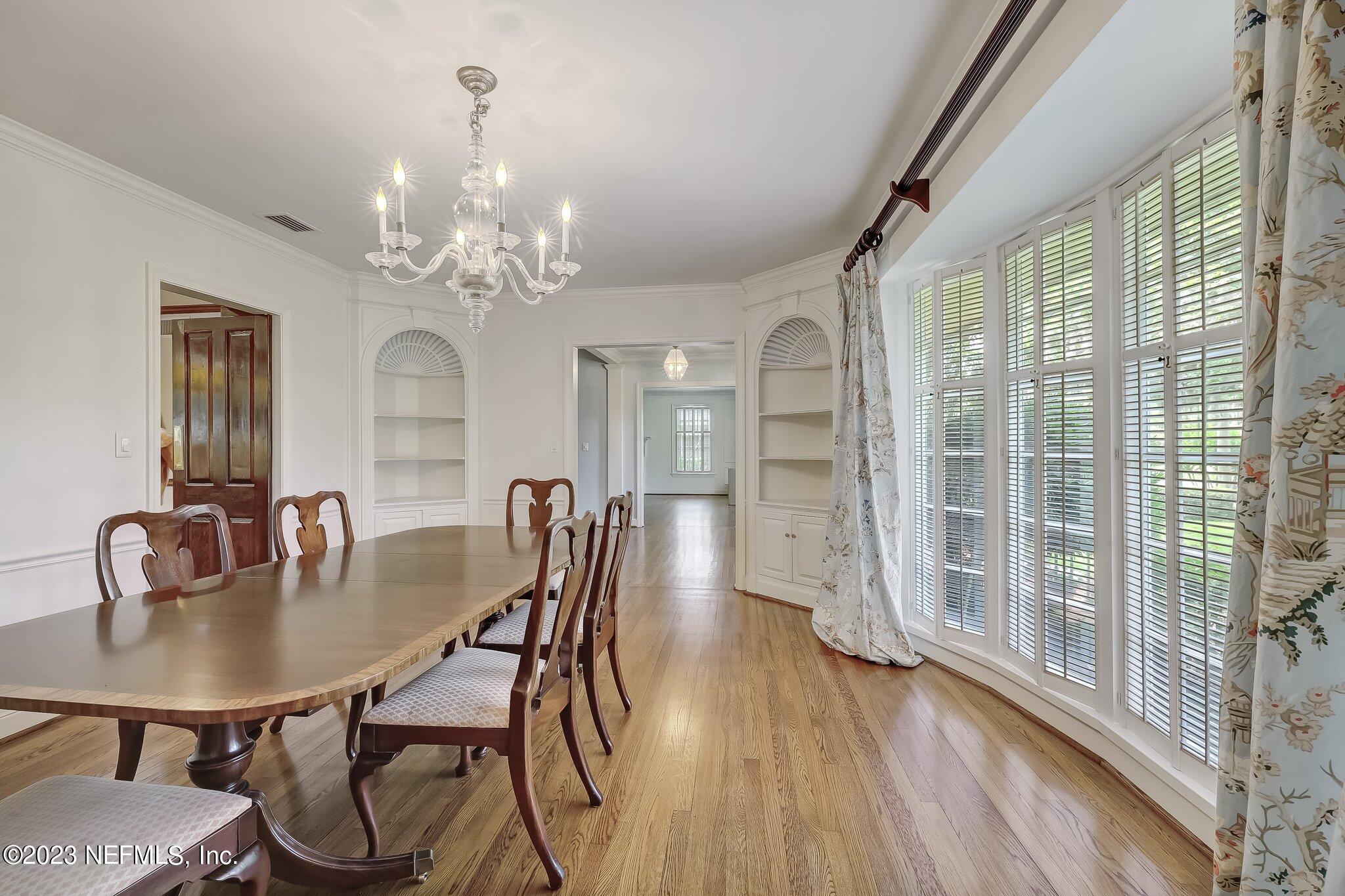 4143 Sherwood Road Jacksonville, FL 32210 - Photo 10 of 67 a dining room with furniture a chandelier and wooden floor