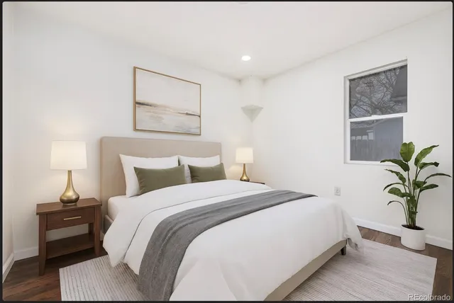 a bedroom with bed and a potted plant