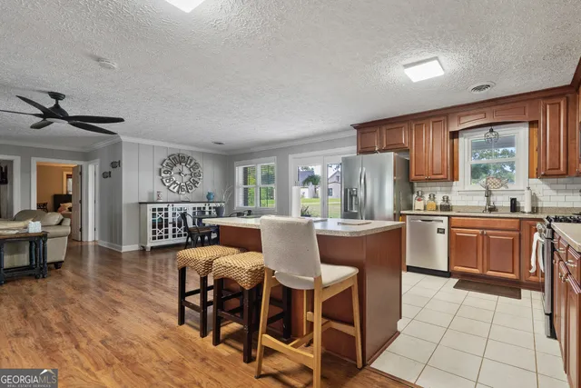 a kitchen with stainless steel appliances granite countertop wooden cabinets a stove top oven a sink and dishwasher
