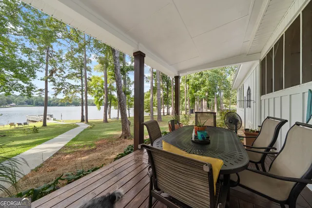 a view of a swimming pool with lawn chairs and wooden fence