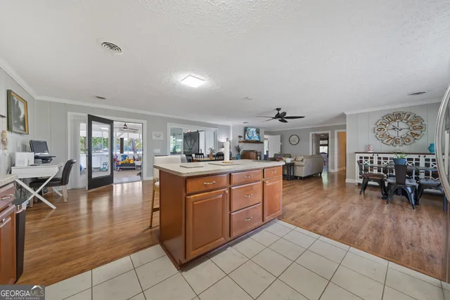 a kitchen with stainless steel appliances granite countertop a stove a sink a refrigerator dining table and chairs