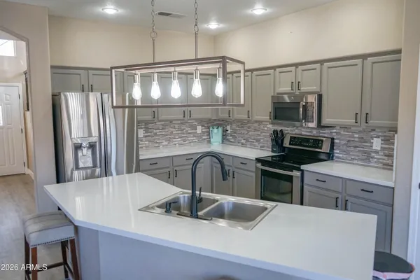 a kitchen with kitchen island a sink appliances and cabinets