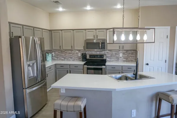 a kitchen with stainless steel appliances a refrigerator a sink and a stove