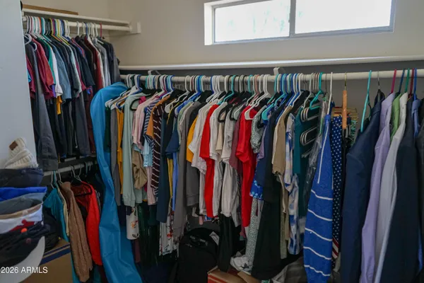 a view of walk in closet with clothes and shoes