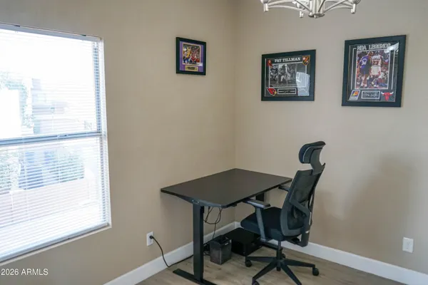 a view of a workspace with furniture and a window