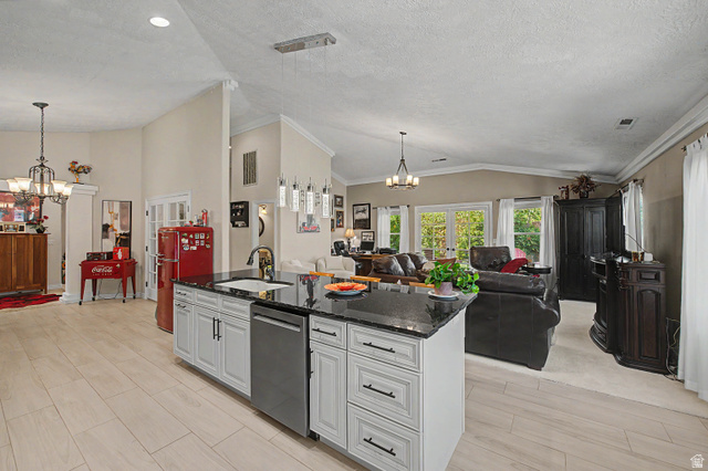 3034 Swiss Drive Santa Clara, UT 84765 - Photo 19 of 59 Kitchen island featuring a black countertop, integrated sink, and stainless steel dishwasher