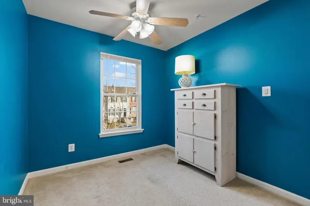a view of a livingroom with a chandelier fan and windows