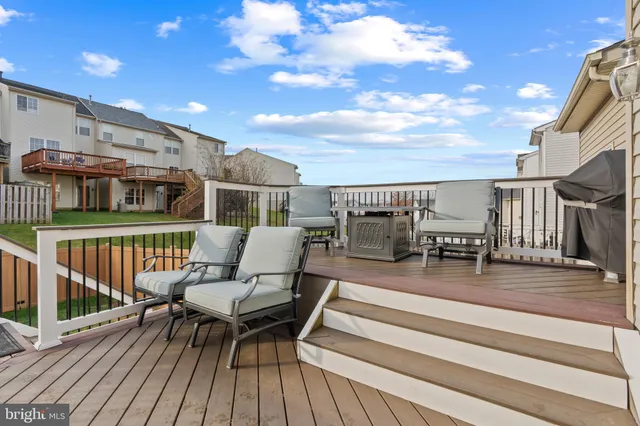 a roof deck with couches and wooden floor