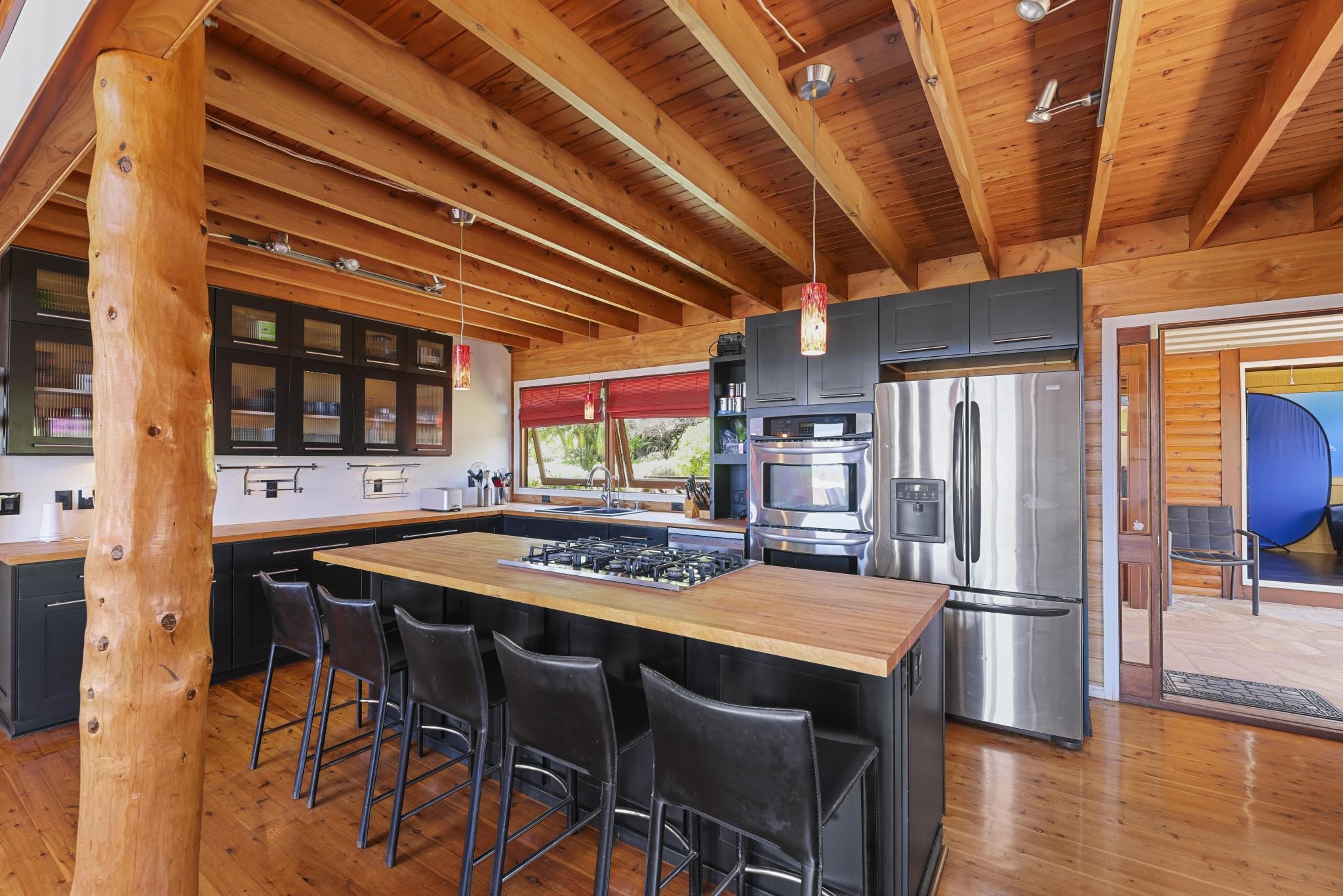 115 Ulua Road Kaunakakai, HI 96748 - Photo 11 of 49 a kitchen with stainless steel appliances granite countertop a table chairs and a refrigerator