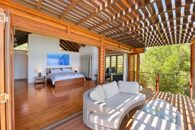 a view of a patio with couches and table and chairs with wooden floor and fence