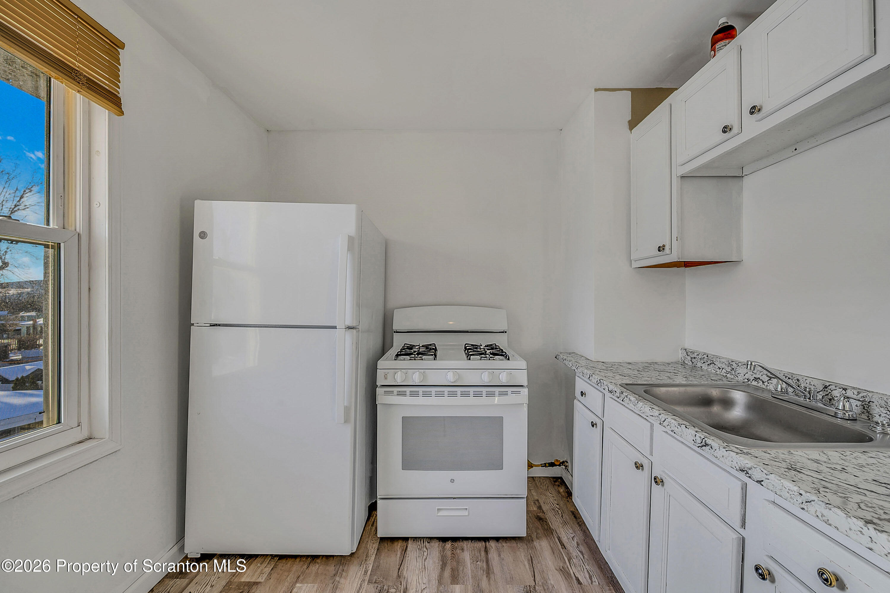 227 North Rebecca Avenue, Unit 2 Scranton, PA 18504 - Photo 4 of 18 a kitchen with a refrigerator sink stove and cabinets
