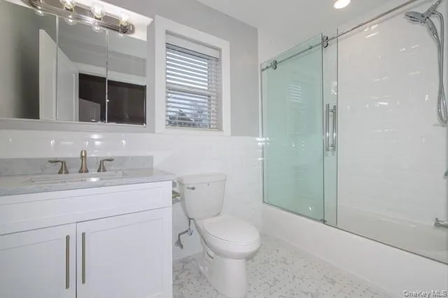 a bathroom with a toilet sink a mirror and shower